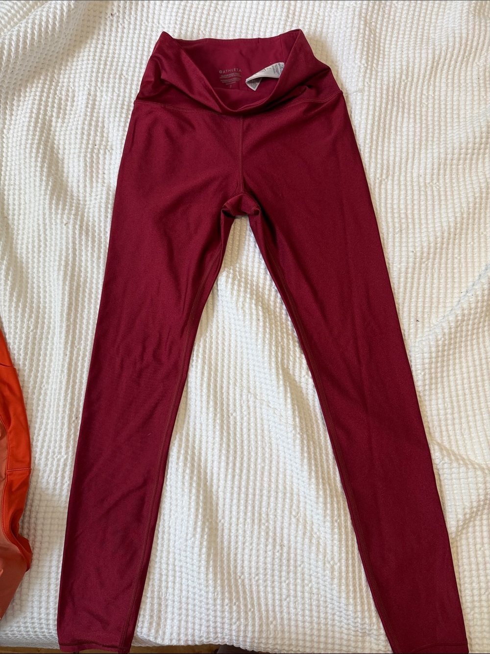 These are Athleta Elation Shine Tight leggings in a decadent red color with a su